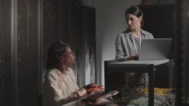 Afrika kökenli Amerikalı ve Kafkasyalı kadınların bilgisayar kullanması, sunucu odasında yazı yazması ve durması, konuşması.