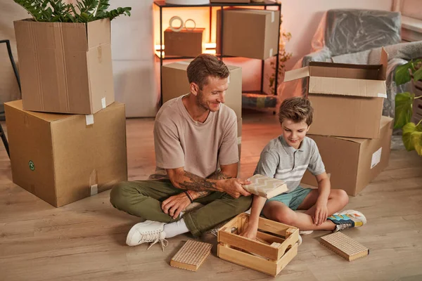 Padre e hijo desempacando cajas en casa nueva — Foto de Stock