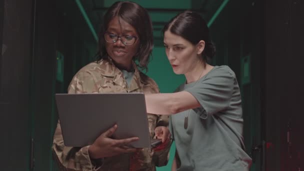 アフリカ系アメリカ人の女性警備員の中には 携帯型コンピュータを持ち 白人の同僚はデバイスを見て データセンターで話していた — ストック動画