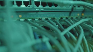 Kabloların takıldığı ender bulunan sunucu dolabının yakın çekimleri, yanıp sönen numaraların olduğu ışıklar.