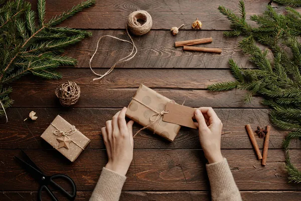 Embrulhando presente de Natal em fundo de madeira — Fotografia de Stock