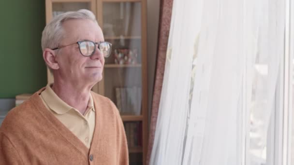 Eingesperrter Älterer Kaukasischer Mann Mit Brille Kommt Zum Fenster Wohnzimmer — Stockvideo