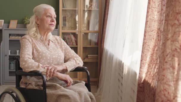 Mediano Largo Pensive Senior Mujer Caucásica Sentado Silla Ruedas Sala — Vídeo de stock