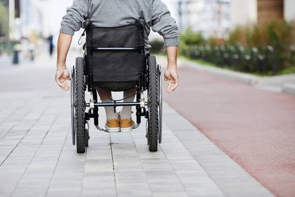 Mann im Rollstuhl fährt im Freien — Stockfoto
