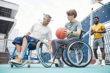 Tekerlekli sandalyeli insanlar basketbol oynuyor