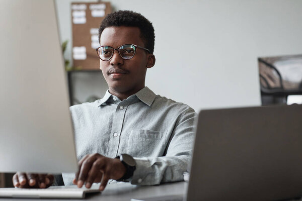Young African American Man Using Computer at Work