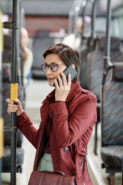 Mulher adulta falando por Smartphone em ônibus — Fotografia de Stock