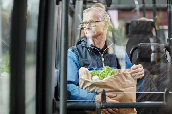 Senior Man Looking at Window in Bus