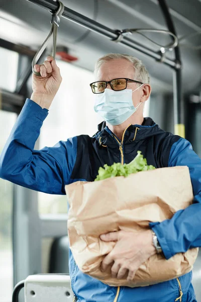 Hombre maduro usando máscara en el autobús — Foto de Stock