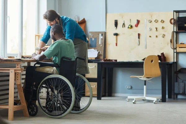 Praktykant korzystający z wózka inwalidzkiego w Warsztacie Produkcji Skóry — Zdjęcie stockowe