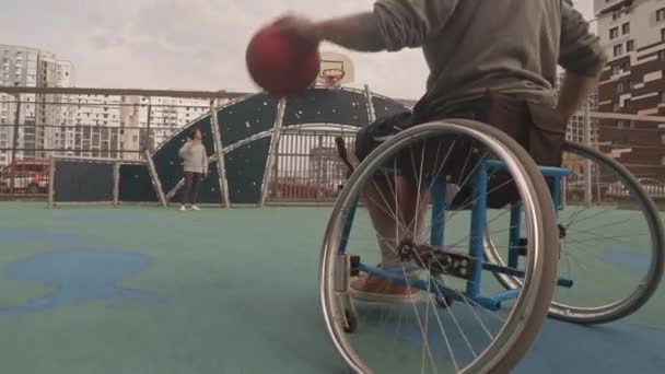 Tieffliegerspur Eines Mannes Rollstuhl Der Freien Auf Einem Basketballfeld Dribbelt — Stockvideo