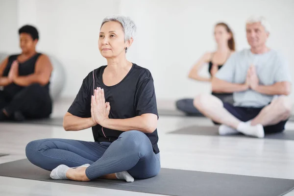 Donna matura che fa yoga in classe — Foto Stock