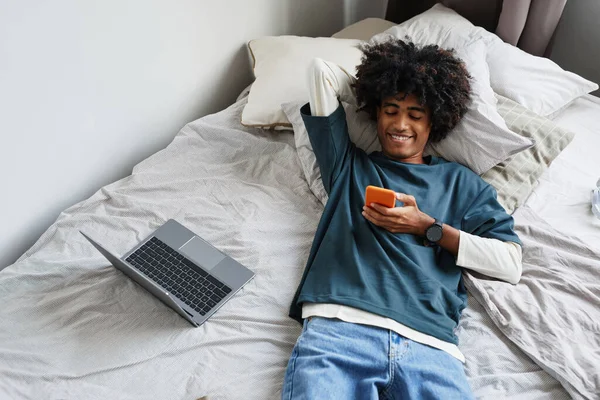 Хлопчик-підліток розслабляється на ліжку вид зверху — стокове фото