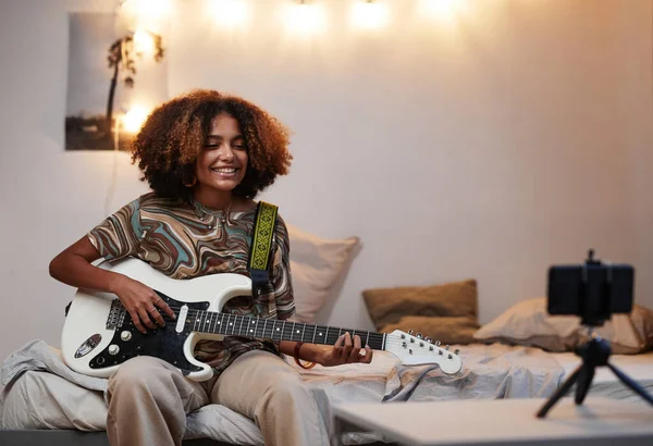 Jovem mulher tocando guitarra em casa — Fotografia de Stock