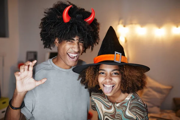 Casal jovem vestindo trajes de Halloween em casa — Fotografia de Stock