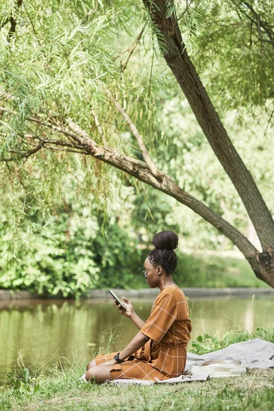 Αφρο-αμερικανίδα νεαρή γυναίκα χαλαρώνοντας στο πάρκο — Φωτογραφία Αρχείου