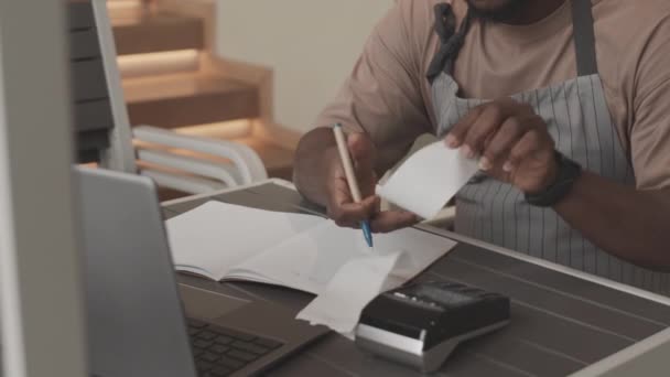 Середній Час Молодого Чорношкірого Фартусі Сидячи Столом Обчислюючи Записуючи Платежі — стокове відео