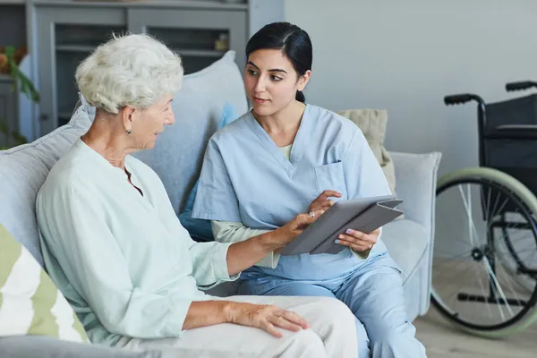 Senior Woman Talking to Nurse in Retirement Home — Stock fotografie