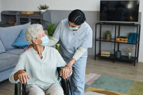 Pielęgniarka opiekuńcza pomaga starszemu w wózku inwalidzkim — Zdjęcie stockowe