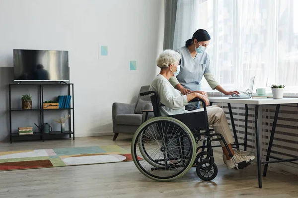 Caregiver Helping Senior in Wheelchair — Stock Photo, Image