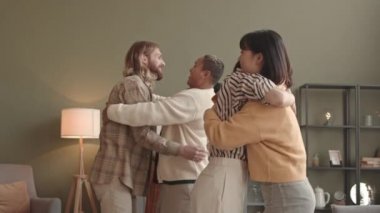 Uzun bir süre apartmanda buluştuktan sonra, ön planda konuşan ve hayran olan Asyalı ve Kafkasyalı kadınların genç çok ırklı dostların birbirlerine sarılıp kucaklamalarına orta açıdan bakıldığında,