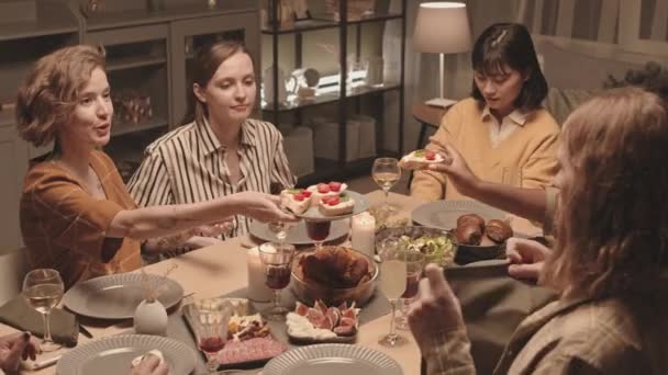 코카서스 여성의 각도에서 친구들에게 체타와 접시를 제공하고 식사를 테이블에 이야기하며 — 비디오