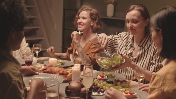 자리에서 이야기하고 웃으며 민족의 친구들에게 샐러드와 그릇을 제공하는 캅카스 여성의 — 비디오