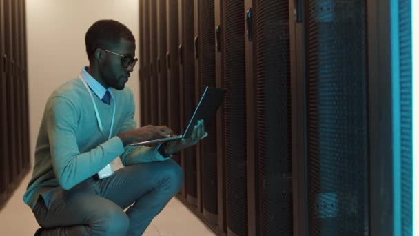 Medium Shot Van Jonge Afrikaanse Mannelijke Beheerder Hurken Rack Server — Stockvideo