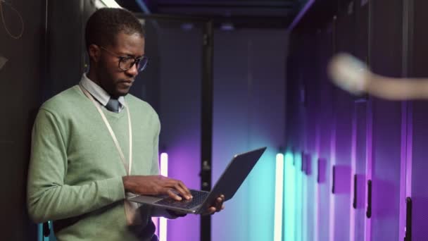 Strzał Ostrości Młodego Afroamerykanina Ubraniach Okularach Pracującego Laptopie Stojącego Centrum — Wideo stockowe