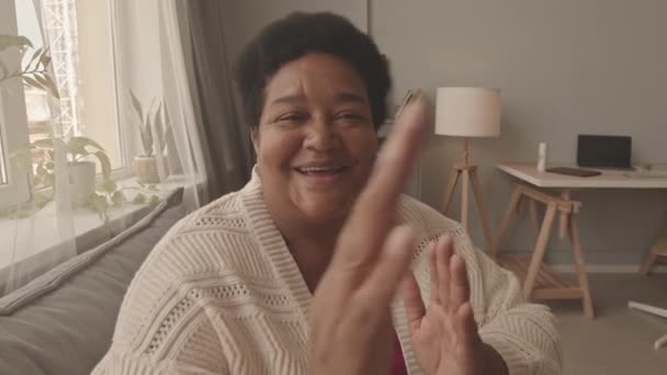 Сундук Пожилой Афроамериканки Сидящей Дома Диване Улыбающейся Играющей Похлопывание Плечу — стоковое видео