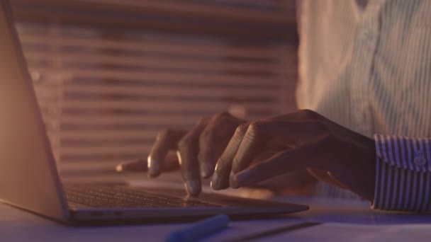 Karanlık Ofisteki Dizüstü Bilgisayarda Klavyeyle Yazı Yazan Tanınmayan Siyahi Erkek — Stok video