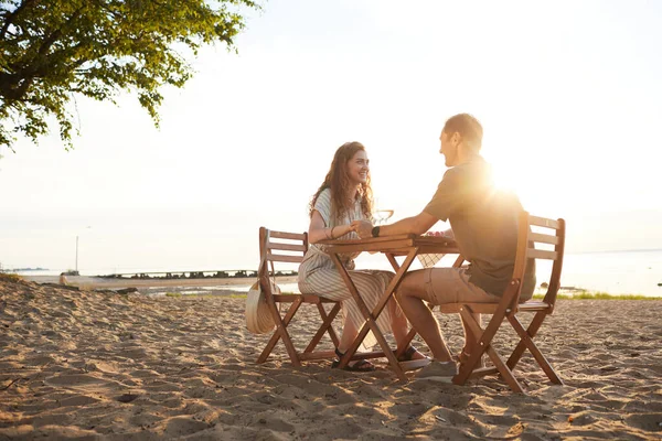 Casal desfrutando de piquenique na praia — Fotografia de Stock