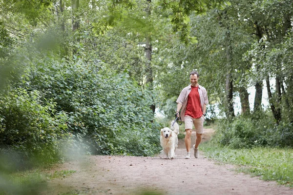 Hombre joven con perro en el parque —  Fotos de Stock