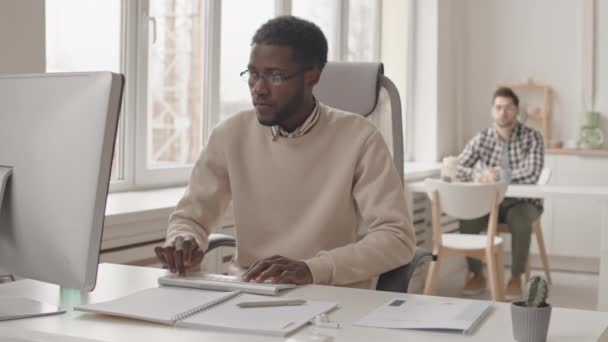 사무실에서 컴퓨터를 연구하고 아프리카 미국인 남자의 미디엄 — 비디오