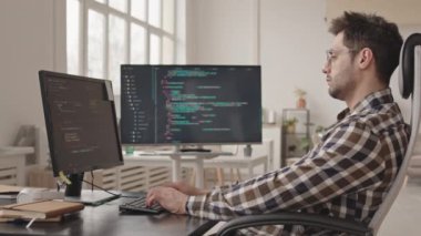 Modern ofiste tek başına çalışan profesyonel sistem yöneticisinin ya da yazılım geliştiricisinin bilgisayar üzerinde program kodları yazışının yan görüntüsü