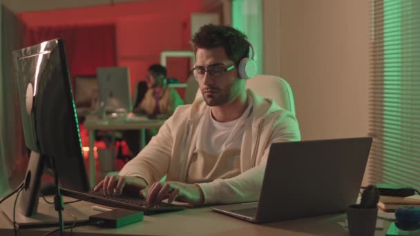 스테브 미디어는 어두운 사무실에서 컴퓨터와 노트북을 작동하는 평상복 전문가의 동작으로 — 비디오