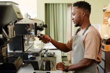 Müşteri için kahve yapan adam.