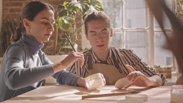 Genç Bayan Çömlekçinin Çömlekçilik Atölyesinde Seramik Nesnelerin Nasıl Boyandığını Gösteren — Stok video