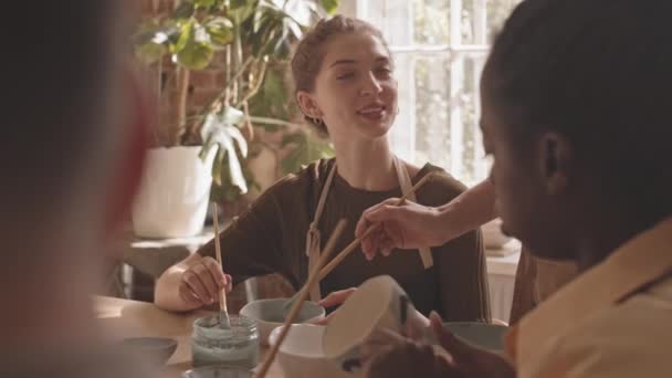 Slowmo Chest Shot Young Caucasian Woman Attending Group Pottery Masterclass — стоковое видео