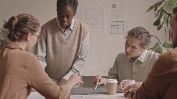 Lento Disparo Del Equipo Jóvenes Diseñadores Multiétnicos Discutiendo Planos Mesa — Vídeos de Stock