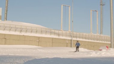 Beyaz tenli sporcu erkek sporcunun düşük açılı görüntüsü güneşli bir günde açık havada beyaz kar üzerinde hızlı bir şekilde kayak yaparak kavis yapıyor.