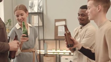 Afrika kökenli Amerikalı ve Kafkas erkek ve genç kadın bira içip şişe tokuşturuyor, şirket partileri düzenliyor ve gündüzleri ofiste konuşuyorlar.