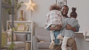 Rahat evlerinde sarılmak için Afrikalı-Amerikalı babalarına koşan iki küçük kızın yavaş çekimleri.