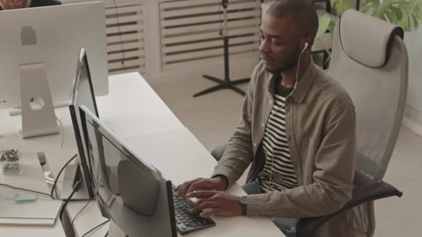 在现代程序员办公室电脑上工作的年轻非裔美国人的中慢镜头 — 图库视频影像