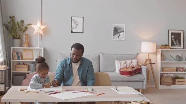 2人の娘と居心地の良い家にいるアフリカ系アメリカ人の男の中低速ショット チャットと一緒に描画 — ストック動画