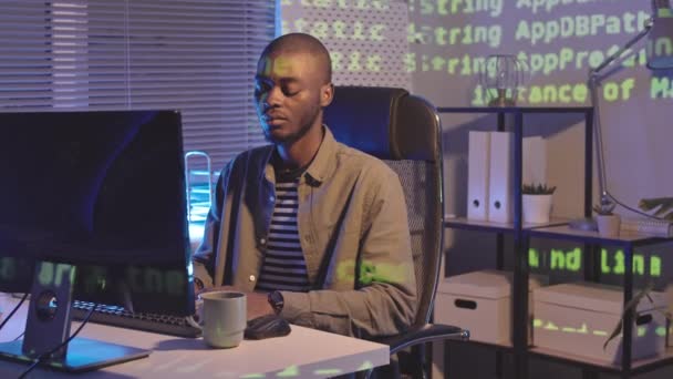 Średnie Ujęcie Kodu Programowego Wyświetlanego Komputerze Młodego Afroamerykanina Pracującego Biurze — Wideo stockowe