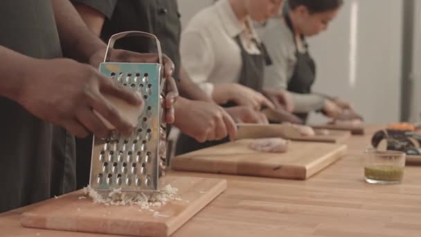 Ahşap Kesim Tahtasının Üstünde Peynir Rendeleyen Arka Planda Profesyonel Mutfakta — Stok video