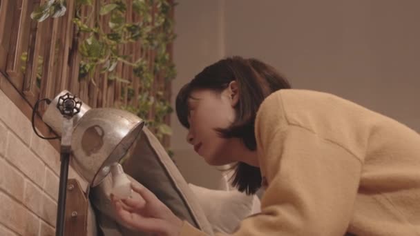 Slowmo Shot Young Asian Woman Screwing Light Bulb Lamp Nightstand — Stock Video