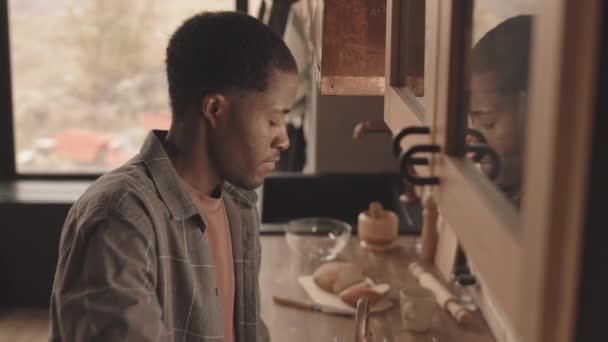 在家里做家务活时 用喷雾和布擦拭木制厨房桌子的非洲裔年轻人的慢镜头 — 图库视频影像