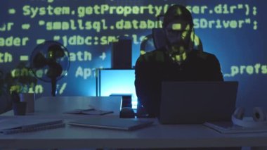 Akşamları bilgisayarla çalışan Kafkasyalı genç bir programcıya programlama kodunu yansıtırken orta ölçekli çekim